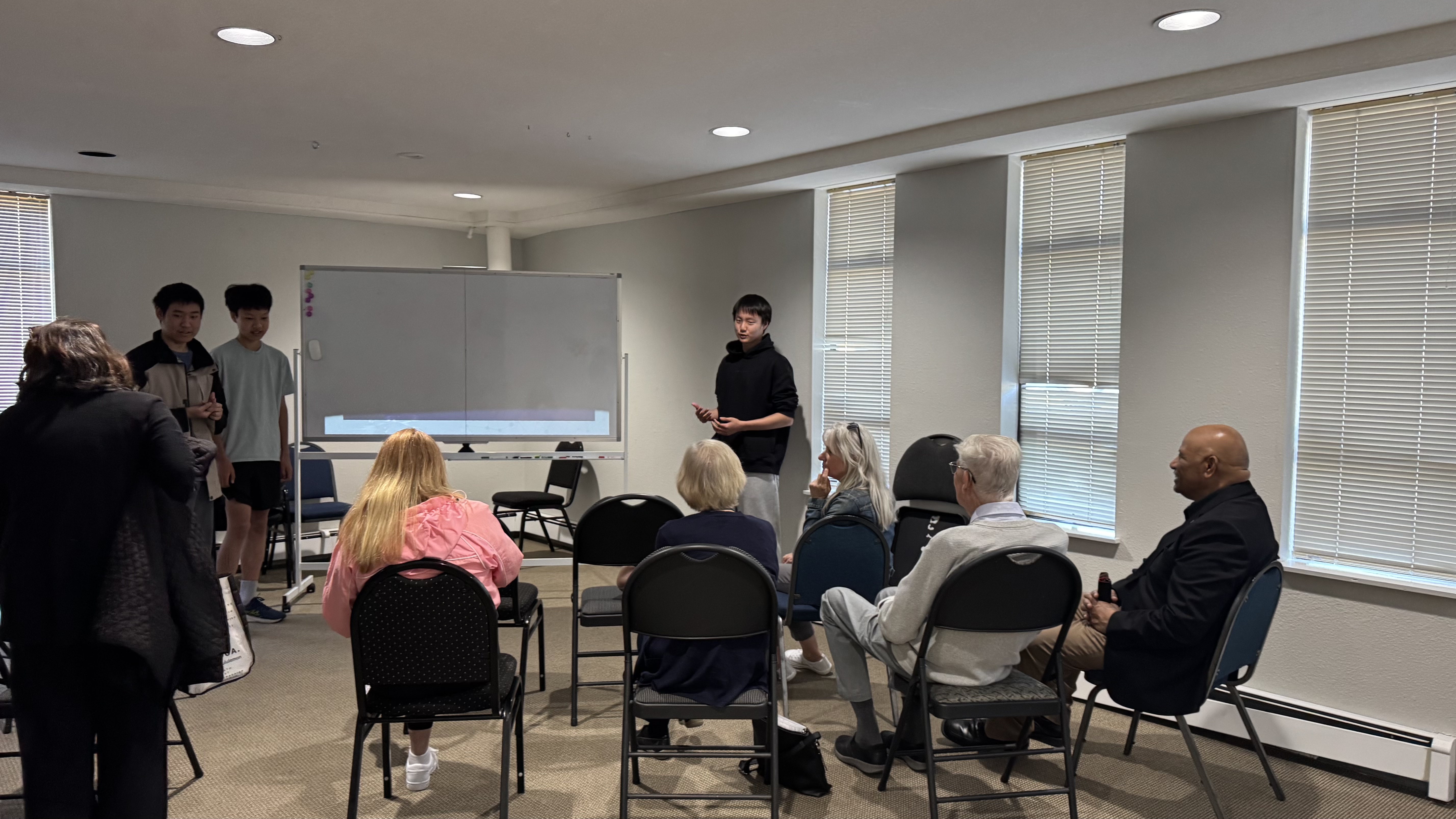 Student volunteers presenting at our first community AI workshop on April 26, 2025